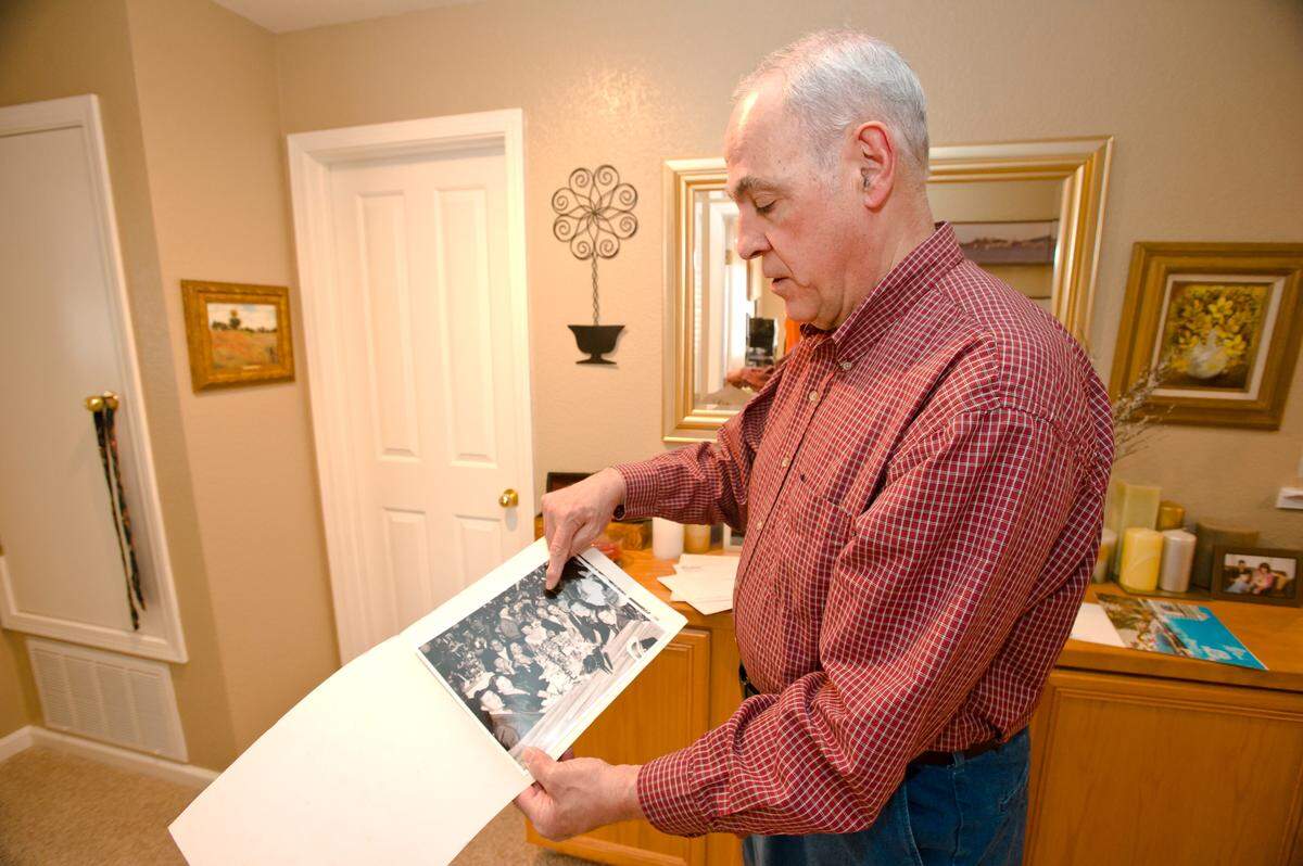 Richard DiMare looks over family photographs in his Sparks, Nevada, home, on Tuesday, March 15, 2011. In the decades after his father’s murder, he continued to work to get the Miami-Dade authorities to investigate the case. 