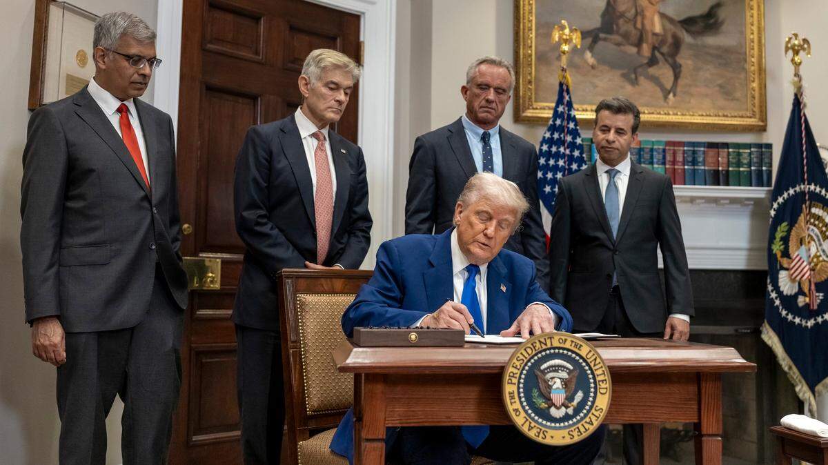 President Donald Trump signs an executive order on Delivering Most-Favored-Nation Prescription Drug Pricing to American Patients at a press conference with Health and Human Services Secretary Robert F. Kennedy Jr., second from right.