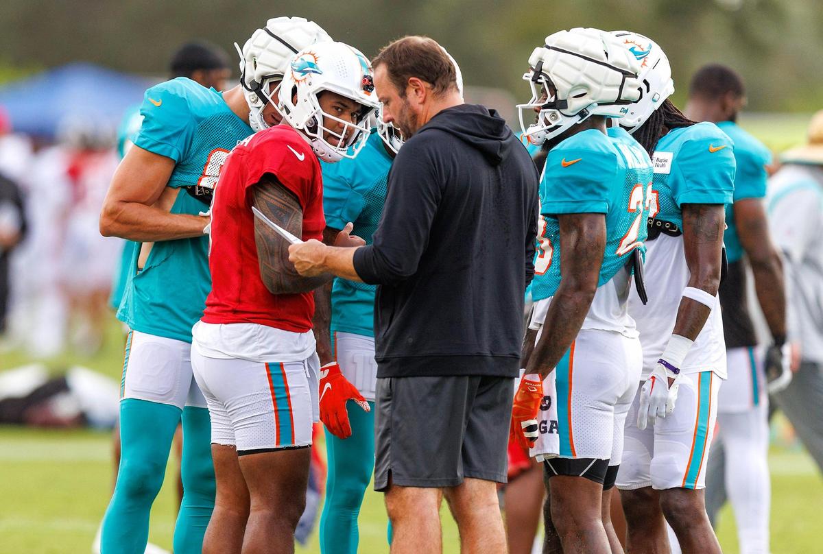 Miami Dolphins offensive coordinator Frank Smith talks with Dolphins quarterback Tua Tagovailoa (1) during a joint practice with the Atlanta Falcons at Baptist Health Training Complex in Hard Rock Stadium on Wednesday, August 9, 2023 in Miami Gardens, Florida.