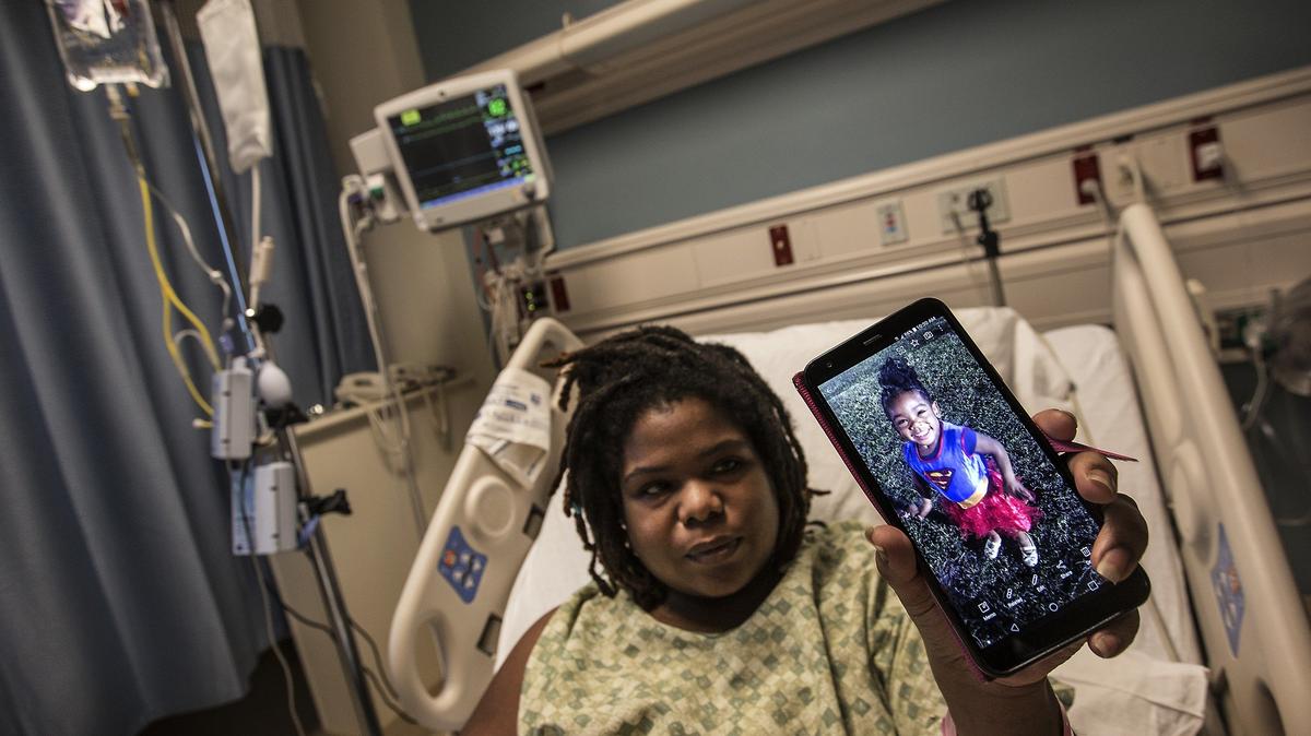 Danaricka Jenkins who struggles with sickle cell disease and has dialysis twice a week, shows a picture of her 3 year-old duaghter Zuri as she lies in a bed at Aventura Hospital hospital on Thursday December 13, 2018 while dealing with pneumonia.
