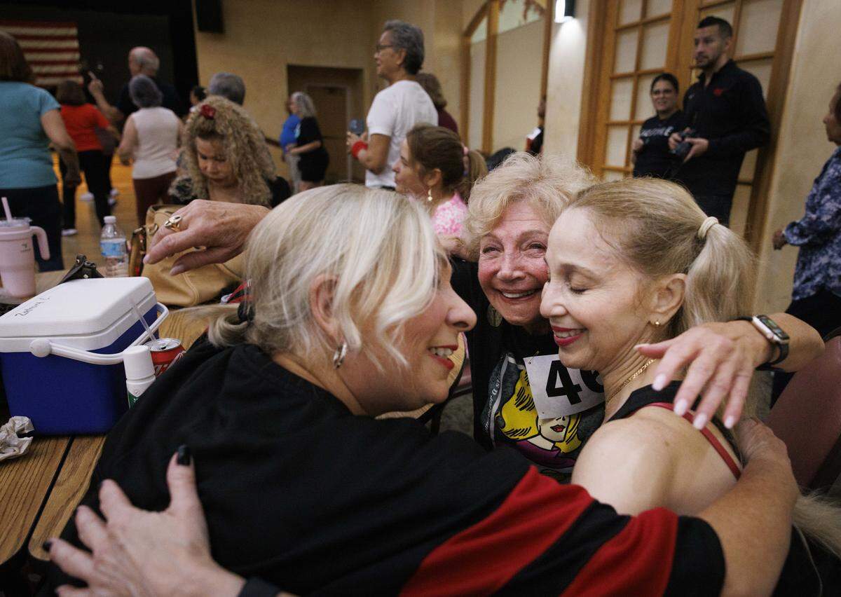 Miriam Cabrera, 66, left, hugs “Tinkerbell”, 80, center, and Mari Redondo, 61, before the HEAT Golden Oldies auditions start for the Miami Heat senior dance team on Thursday, Sept. 25, 2025, at Southwest Focal Point Community Center in Pembroke Pines, Fla. “We all just met here but we’re already friends! Everyone is so happy to be here,” said Tinkerbell.