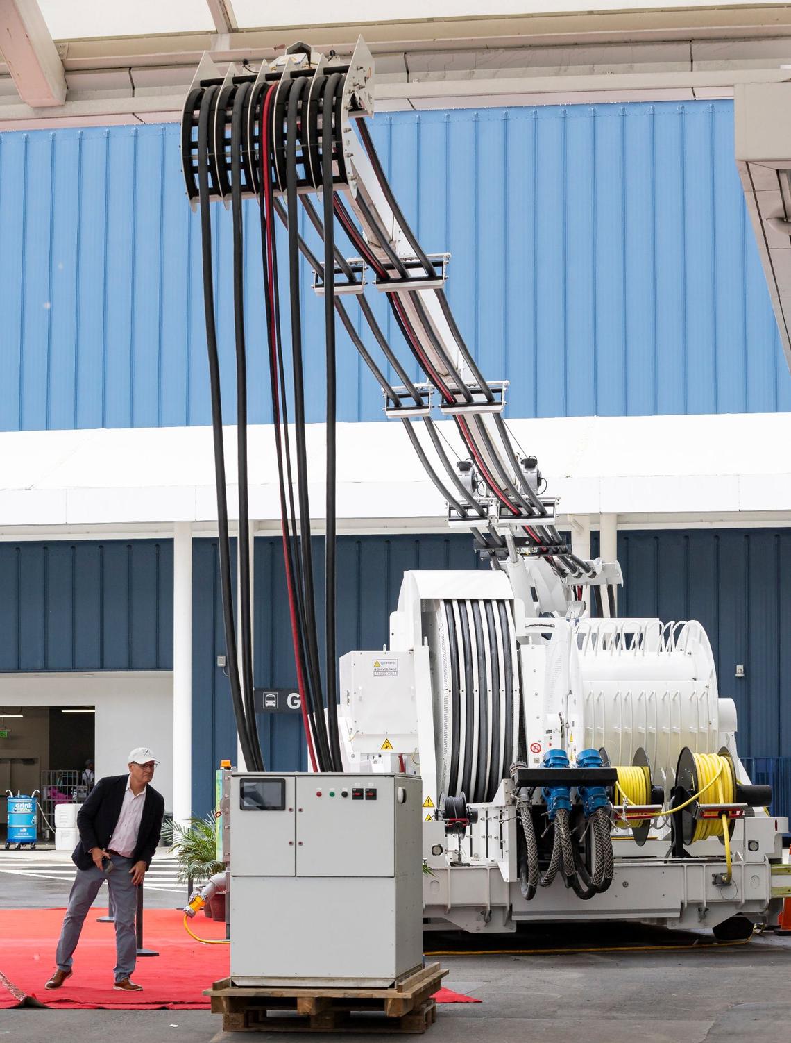 A man takes a closer look at a shore power system during a ribbon cutting event at PortMiami on Monday, June 17, 2024, in Miami, Fla. The event officially launched shore power at PortMiami, allowing cruise ships to turn off their engines and plug into a land side electrical power while docked, resulting in reduced emissions and noise.