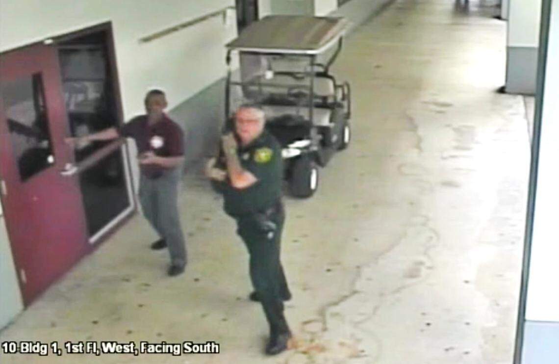 This Feb. 14, 2018, frame from security video provided by the Broward County Sheriff’s Office shows Deputy Scot Peterson, right, outside Marjory Stoneman Douglas High School in Parkland, Fla. He was severely criticized for not entering the school to confront shooter Nikolas Cruz. This image was from video released March 15. On Wednesday, Aug. 22, the Florida Supreme Court declined to intervene in a lawsuit, allowing more surveillance video would be released.