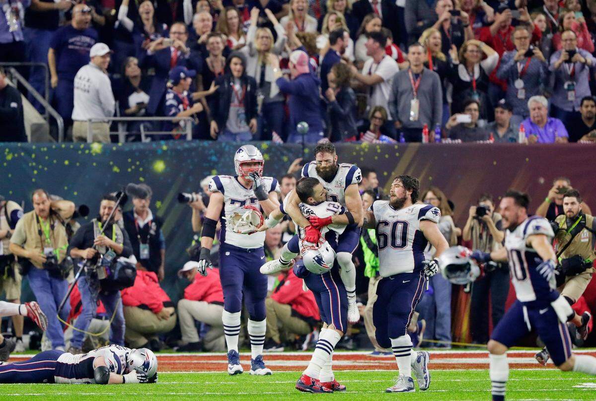 Patriots quarterback Tom Brady celebrates with Julian Edelman (11) after New England came from 28-3 down to beat Atlanta 34-28 to win Super Bowl 51, the first Super Bowl to go into overtime.