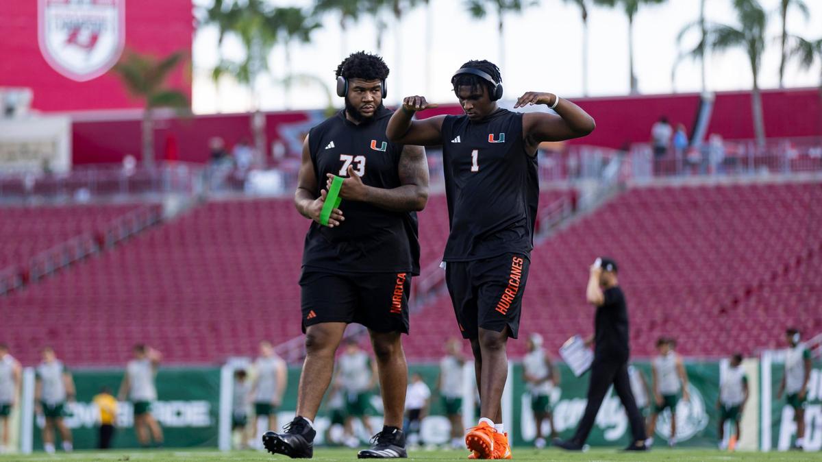 Miami Hurricanes offensive lineman Anez Cooper (73) and quarterback Cam Ward (1) warm up before the start of their NCAA college football game against the South Florida Bulls at the Raymond James Stadium on Saturday, Sept. 21, 2024, in Tampa, Fla.