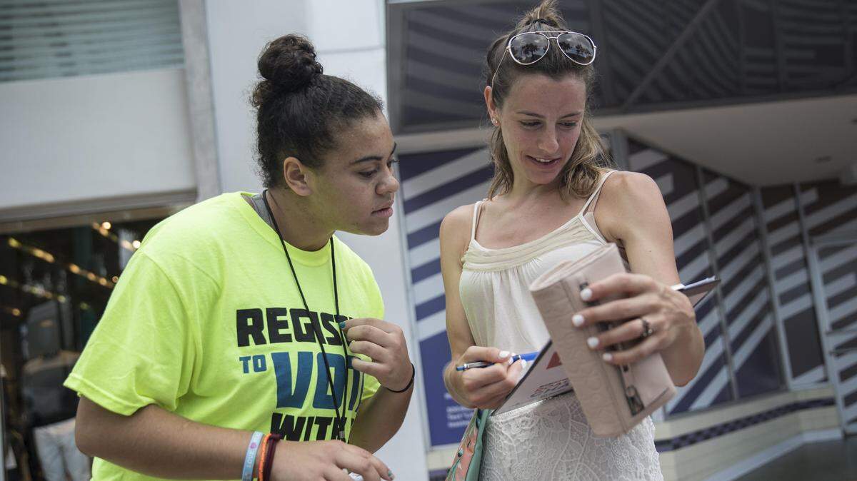 Hannah Karcinell, 18, a recent graduate of Marjory Stoneman Douglas High School, helps Miriahjo Reiss, 25, register to vote on Lincoln Road in Miami Beach on Sunday, June 24, 2018.