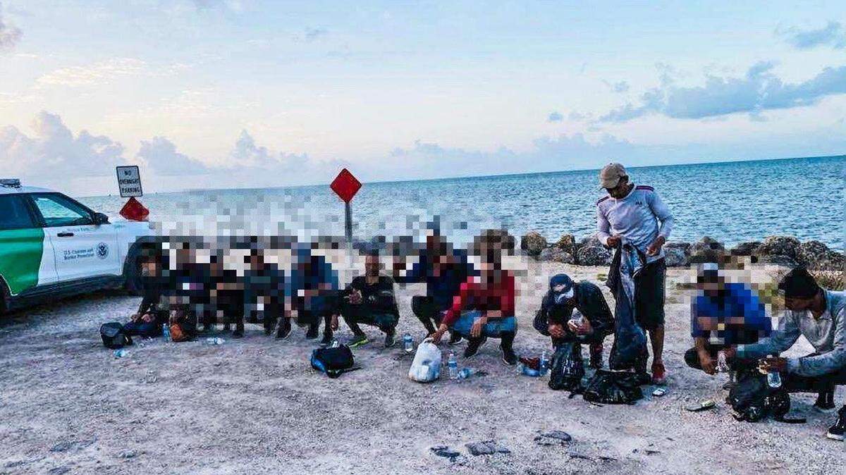 A group of 13 men from Cuba gather on Coco Plum Beach in the Middle Florida Keys city of Marathon Tuesday, May 3, 2022. They were taken into custody by U.S. Border Patrol agents shortly after arriving.