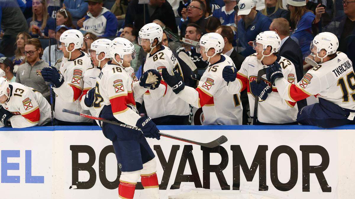 Apr 25, 2024; Tampa, Florida, USA; Florida Panthers center Steven Lorentz (18) is congratulated by center Kevin Stenlund (82), center Anton Lundell (15) and teammates after he scored a goal against the Tampa Bay Lightning during the third period in game three of the first round of the 2024 Stanley Cup Playoffs at Amalie Arena. Mandatory Credit: Kim Klement Neitzel-USA TODAY Sports
