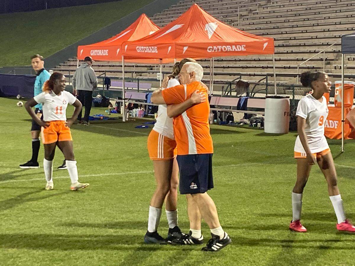 South Florida HEAT girls’ soccer coach Bob Bemis gives one of his players, Hannah Brankamp, a consoling hug after the game on Wednesday night. HEAT lost its Class 1A state semifinal to St. Johns Country Day 6-0 at Spec Martin Stadium in DeLand, Fla.
