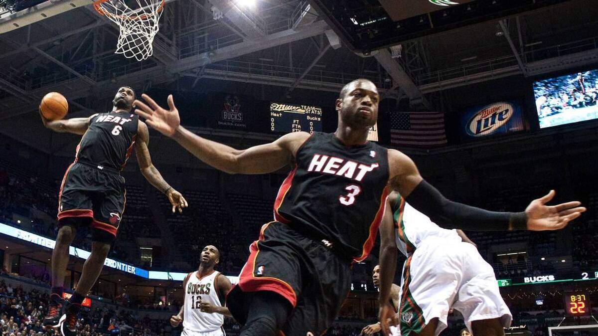 Miami Heat’s Dwyane Wade (3) reacts as teammate LeBron James (6) goes up for a dunk during the first half of an NBA game against the Milwaukee Bucks on December 6, 2010.