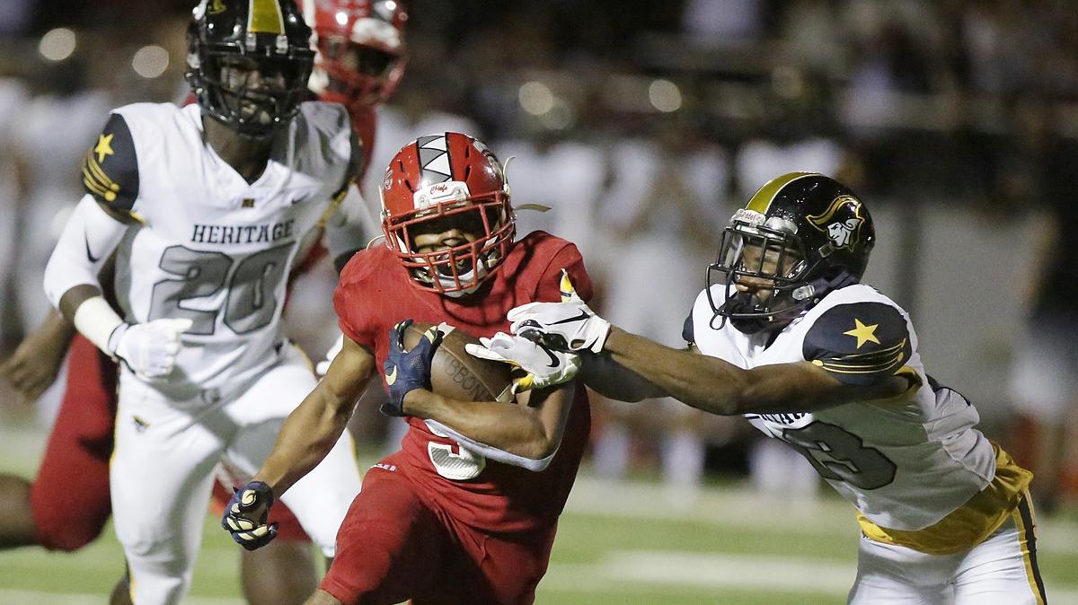 Cardinal Gibbons Chiefs’ running back Vincent Davis (5) tries to escape American Heritage Patriots’ defender during the Region 4-5A final football game on Friday, Nov. 23, 2018 at Cardinal Gibbons High in Fort Lauderdale.