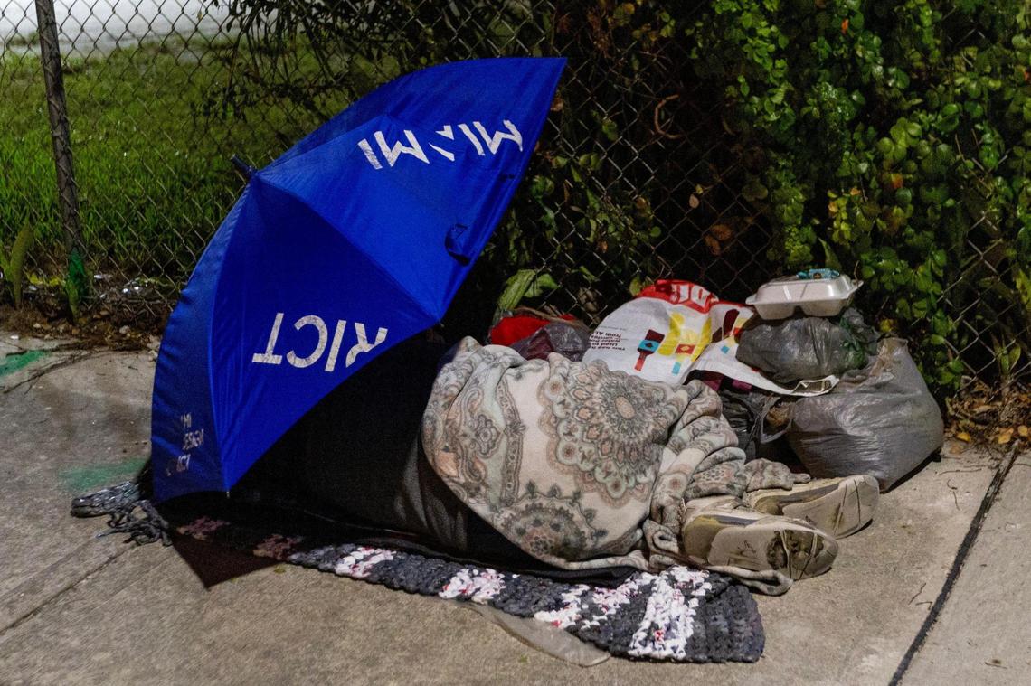 An unsheltered person sleeps on the sidewalk off NW 18th Street in Miami, Florida, on Friday, December 22, 2023.