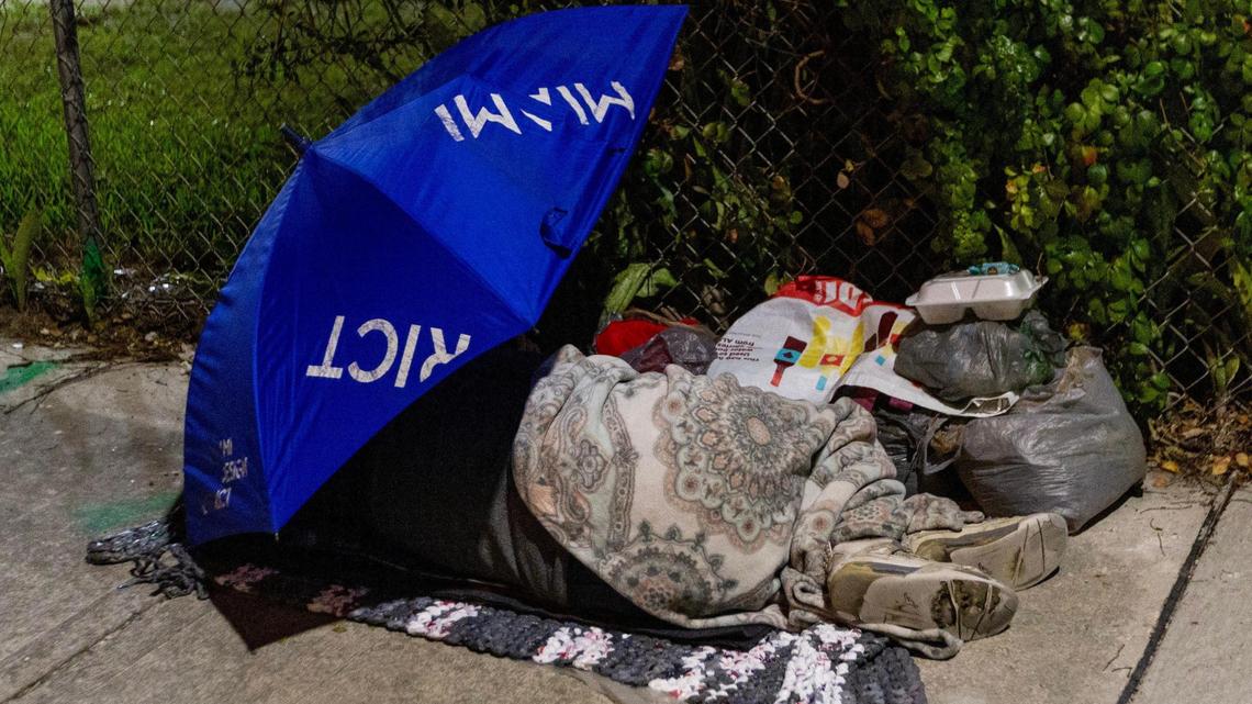 An unsheltered person sleeps on the sidewalk in Miami on Dec. 22, 2023.