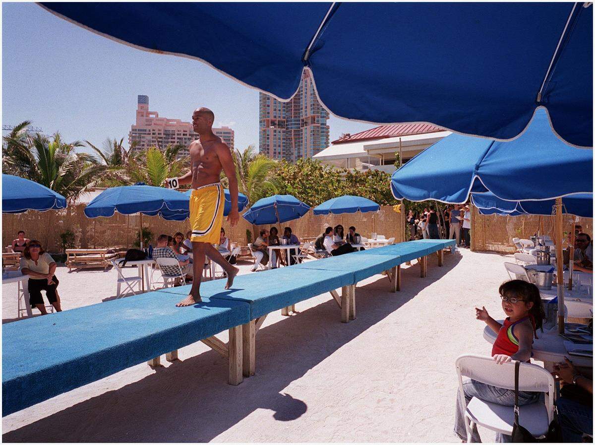With a number in hand, a model walks the catwalk at Nikki Beach as designers get a good look during Miami Fashion Week in 2001.