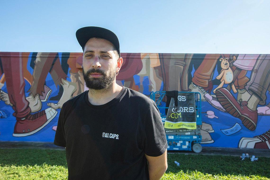 Edoardo Trionfera “Dodici” from Italy poses in front of his mural at Madison Middle School.