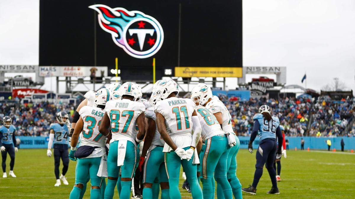 Miami Dolphins players huddle in the second half of an NFL football game against the Tennessee Titans Sunday, Jan. 2, 2022, in Nashville, Tenn. (AP Photo/Wade Payne)