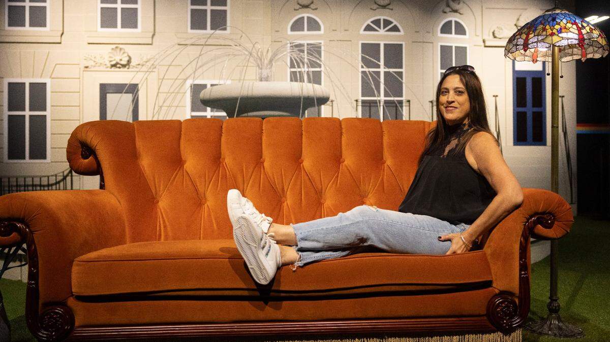 Miami Herald reporter Madeleine Marr poses on a replica of the iconic ‘Friends’ couch at the Friends Experience at Aventura Mall.
