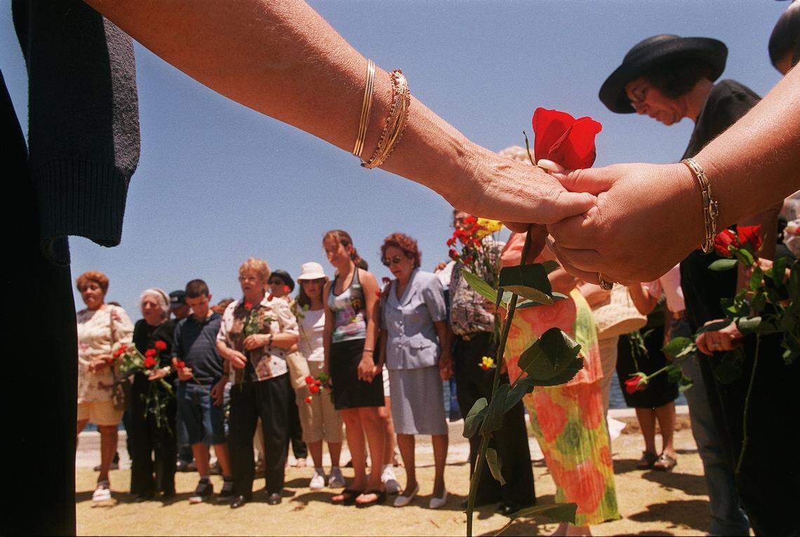 Dozens of people join hands in prayer before tossing flowers into the water in remembrance of Elian Gonzalez’s mother, Elizabeth Brotons, and other mothers who have died for freedom behind Ermita de la Caridad Catholic Church.