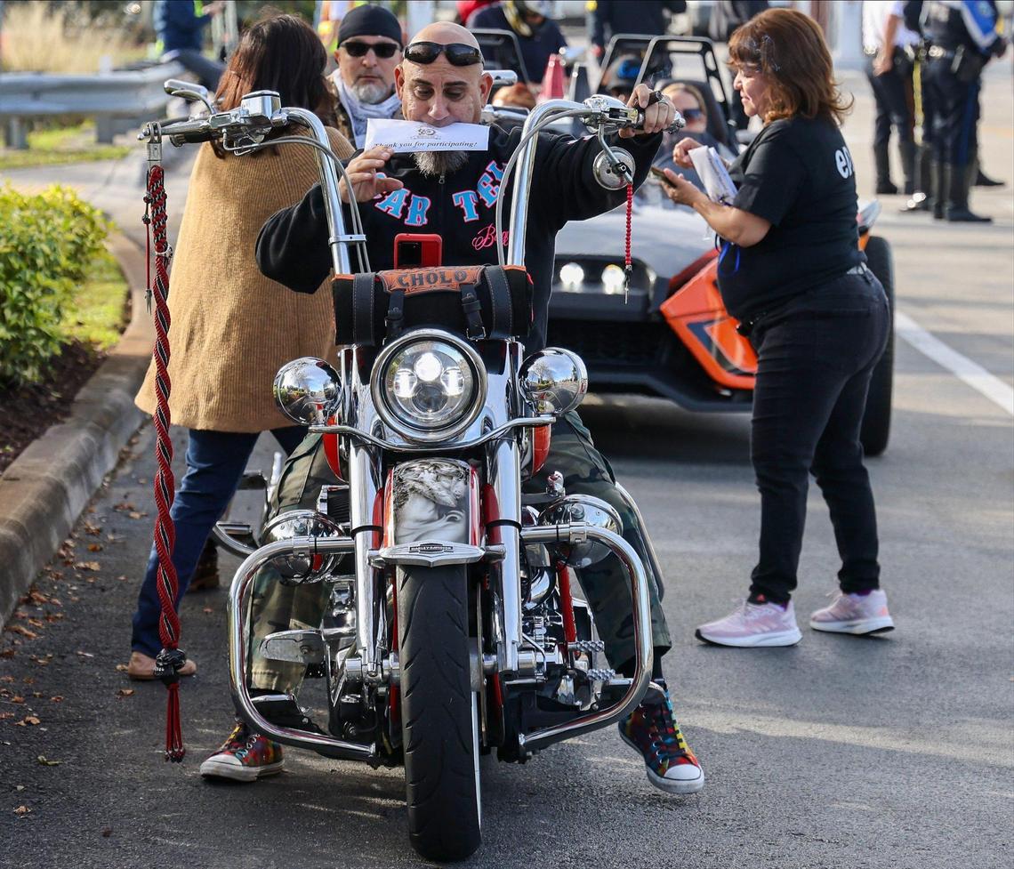 Robert Navarro, 50, grips his receipt between his lips after on-site registering for the event as approximately 350 riders took part in the 13th Annual Archbishop Motorcycle Ride. The event raises funds for the St. Luke’s Center, an alcohol and drug rehabilitation facility in Miami.