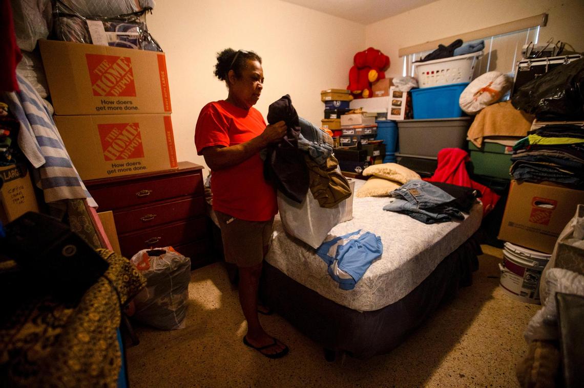 Nora Trujillo, 62, sorts clothing stored atop furniture in an effort to save the items from water damage by flooding that occurred in early June 2022 in the Little Havana neighborhood of Miami.