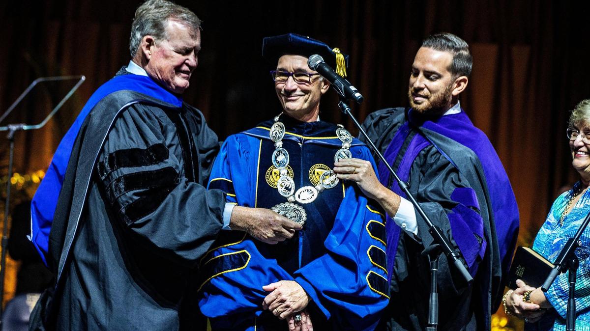 Mrs. Lori Jessell, far right, joined FIU board chair Dean Colson, left, and state Rep. Daniel Perez, R-Miami, as they place the “Chain of Office” on FIU’s sixth president, Kenneth Jessell, center, during his presidential investiture ceremony at the Ocean Bank Convocation Center, Florida International University Modesto A. Maidique campus in Miami-Dade,Thursday May 18 , 2023.