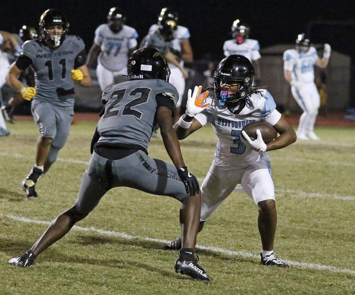 West Broward Bobcats wide receiver Cedric Mitchell Jr. (3) tries to escape a tackle by Western Wildcats defenders during the football game on Thursday, October 30, 2025 at Western HS in Davie. Andrew Uloza / for Miami Herald
