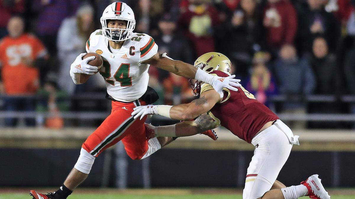 Miami Hurricanes running back Travis Homer (24) runs for a first down in the first quarter as the University of Miami plays Boston College at Alumni Stadium in Chestnut Hill on Friday, October 26, 2018.