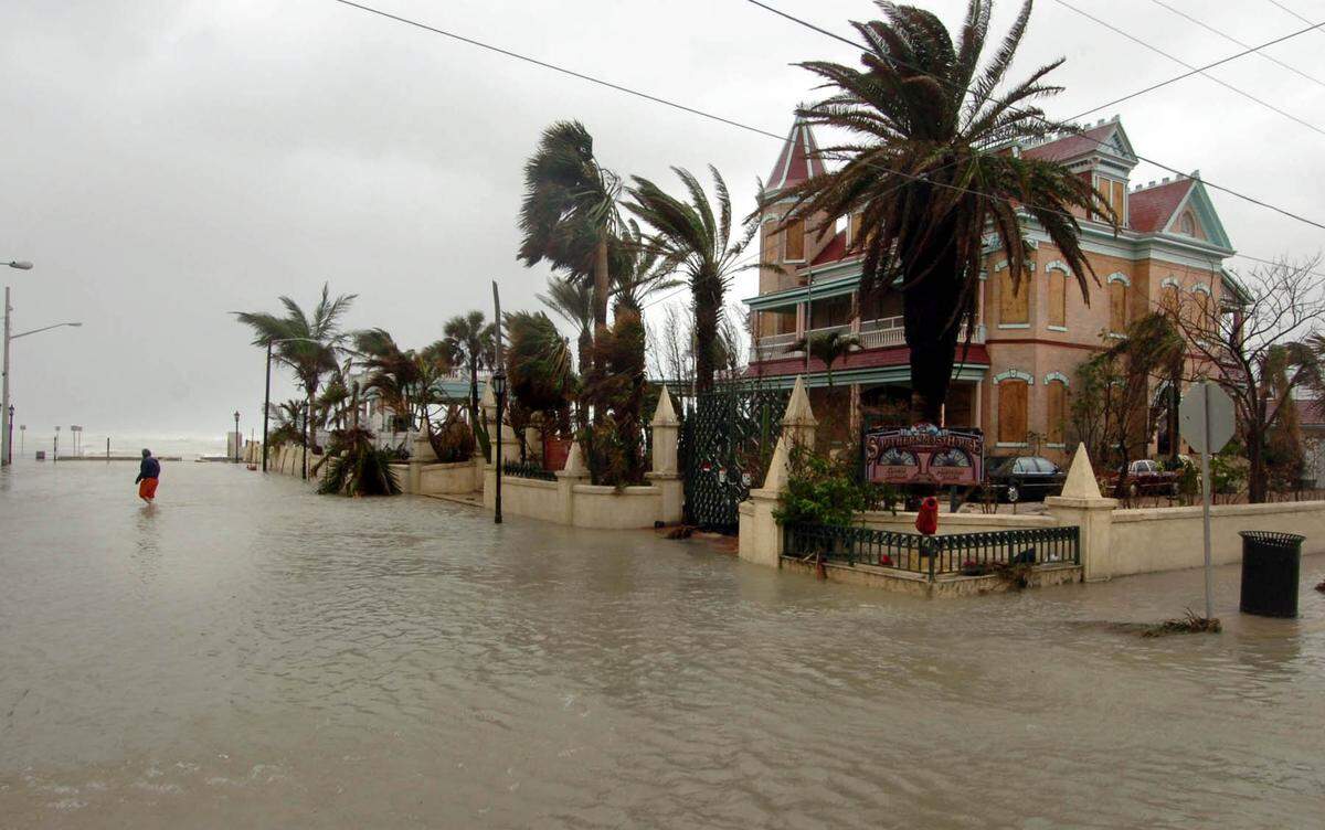 A man crosses eastern Duval Street in Key West past the southernmost house in surge floods caused by Hurricane Wilma in October 2005.