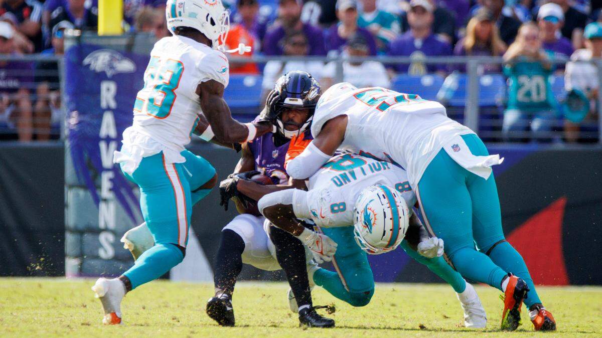 Miami Dolphins cornerback Kader Kohou (28) safety Jevon Holland (8) and linebacker Elandon Roberts (52) brings down Baltimore Ravens wide receiver Devin Duvernay (13) during fourth quarter of an NFL football game at M&T Bank Stadium on Sunday, September 18, 2022 in Baltimore, MD.