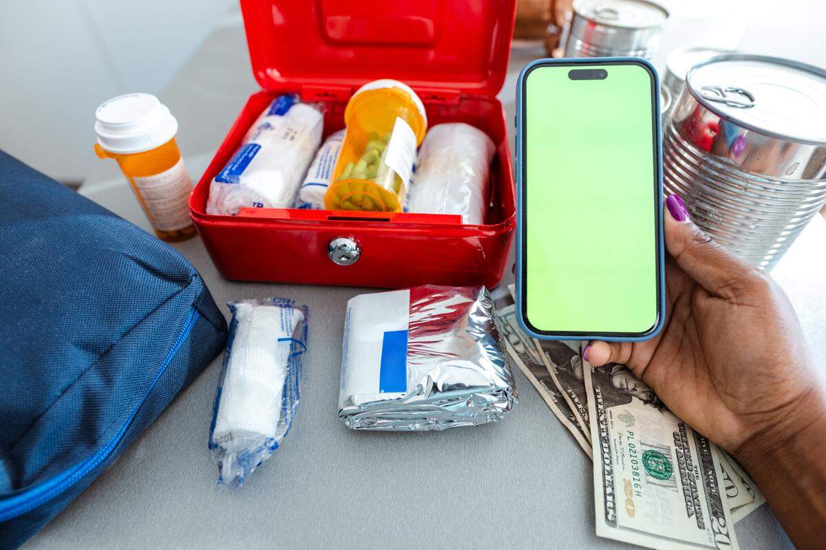 An open first aid kit is being organized, showing medical supplies on a kitchen counter.