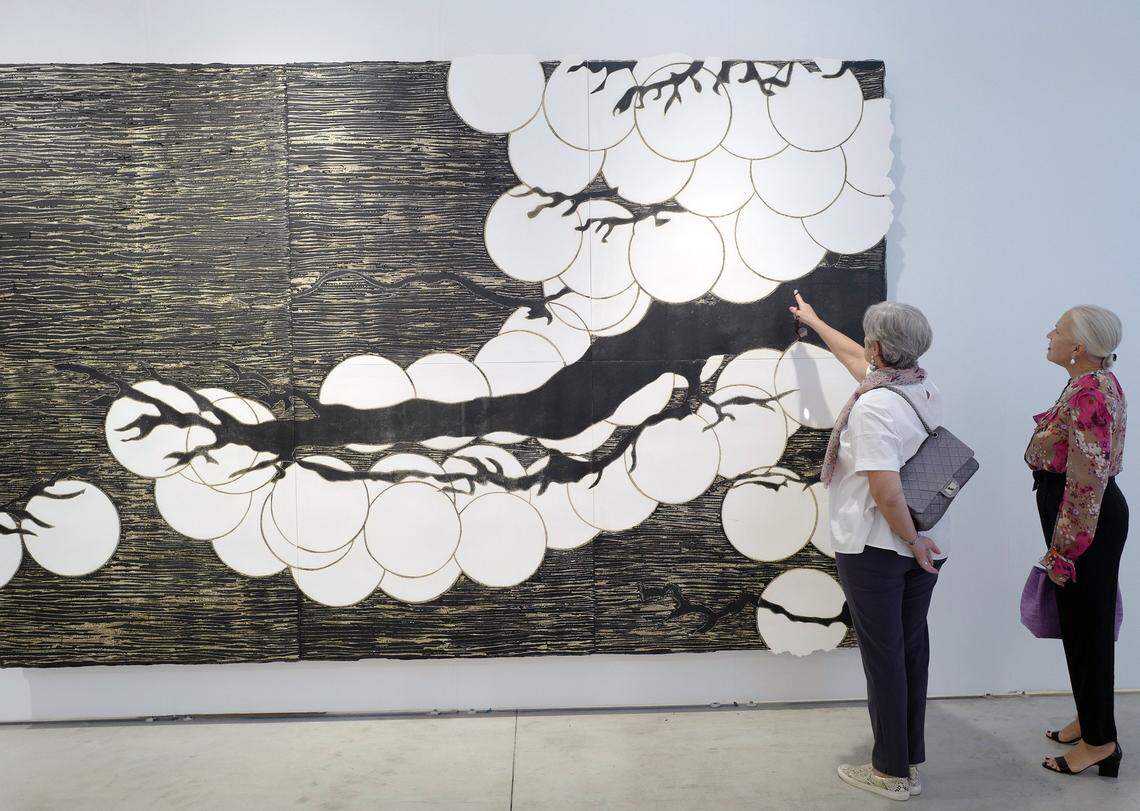 Two women observe the work entitled ‘Japanese Pine’ by the artist Donald Sultan at Art Miami on Dec. 7, 2017.