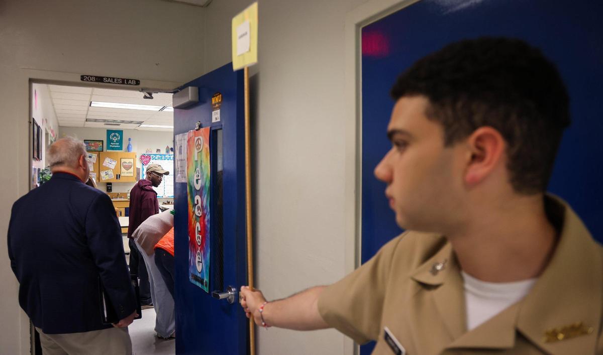 Cadet Jonathan Cuentas, right, stands at attention next to classroom door of where a breakout session was held at the second Broward County Public Schools community meeting to discuss school closures which took place on Feb. 15, 2024.