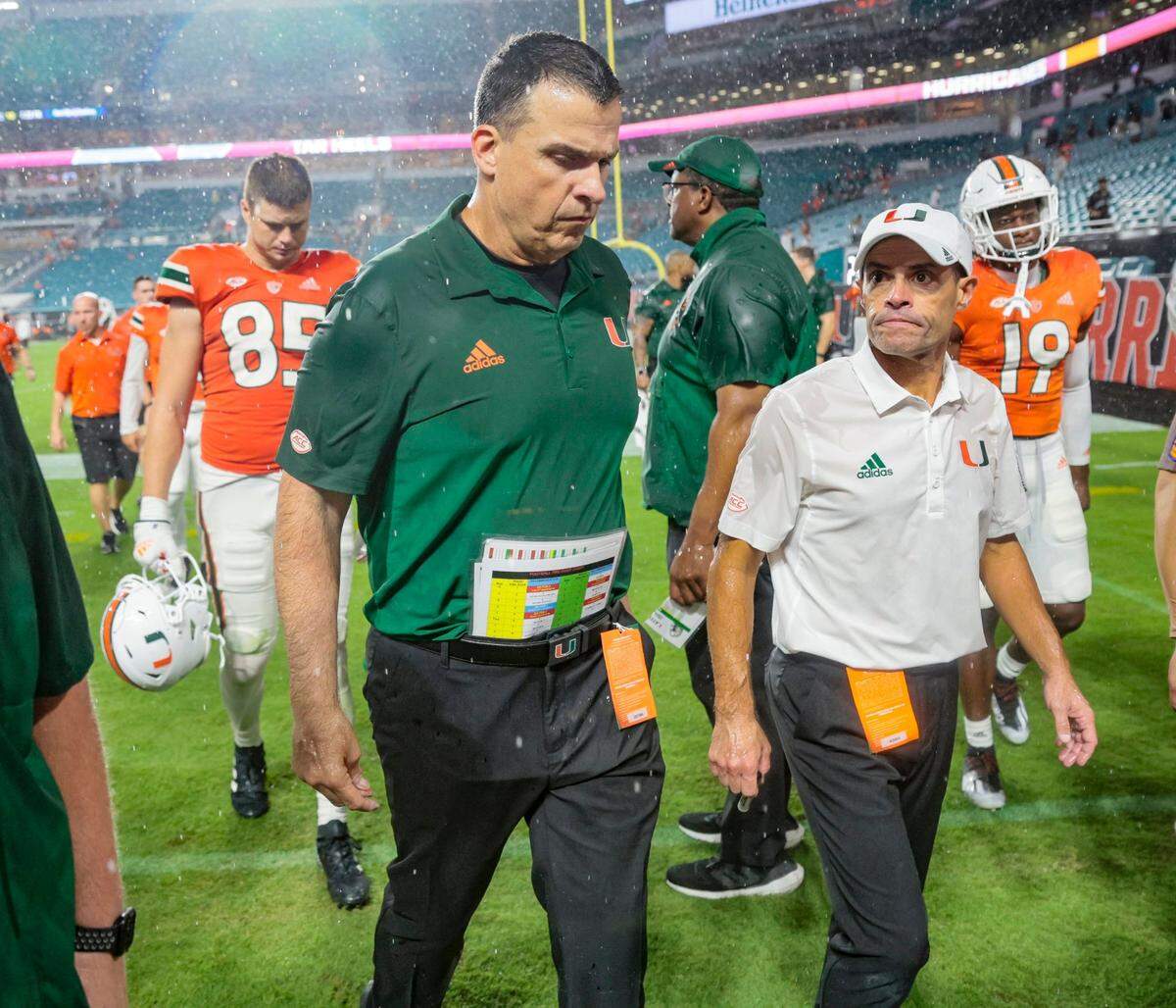 Miami Hurricanes head coach Mario Cristobal and assistant head coach / offensive Line Coach Alex Mirabal walk off the field after loss to Middle Tennessee State Blue Raiders at Hard Rock Stadium in Miami Gardens on Saturday, September 24, 2022.