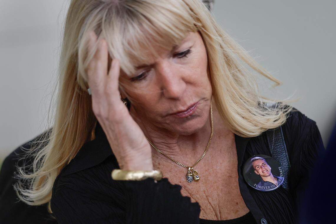 Annika Dworet, wears a button the shows a photograph of her son, Nicholas Dworet, as the families of students killed during the Marjory Stoneman Douglas High School shooting hold a press conference at Pine Trails Park Amphitheater in Parkland, Florida on Thursday, February 5, 2026. They addressed legislation, Broward Sherriff's office and the eight years since the mass shooting occurred when 19-year-old Nikolas Cruz opened fire on students and staff.