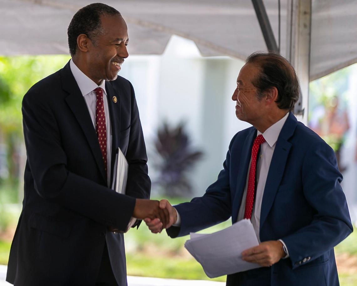 HUD Secretary Dr. Ben Carson shakes hands with Michael Liu, director of Miami-Dade Public Housing and Community Development, during the grand opening ceremony of the first phase of the Liberty Square redevelopment in Miami, Florida, on Monday, July 1, 2019.