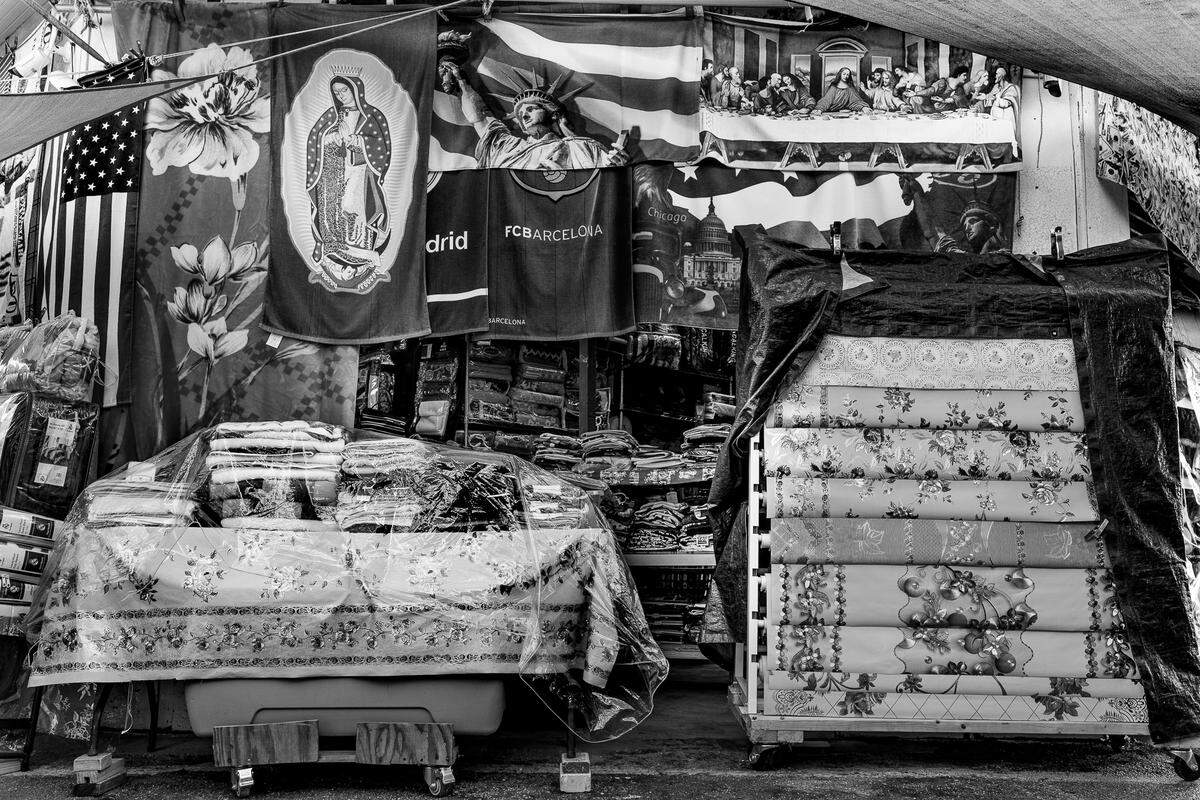 “For Everyone,” by Carlos “Cali” Muñoz, part of the Belonging in Transit exhibit at HistoryMiami Museum. This photograph of a workstation at Redland Market Village captures how religion, nationality, sport and personal identity are expressed. Each element in the image represents something unique, offering a glimpse into the lives and stories of the people who make the market their own.
