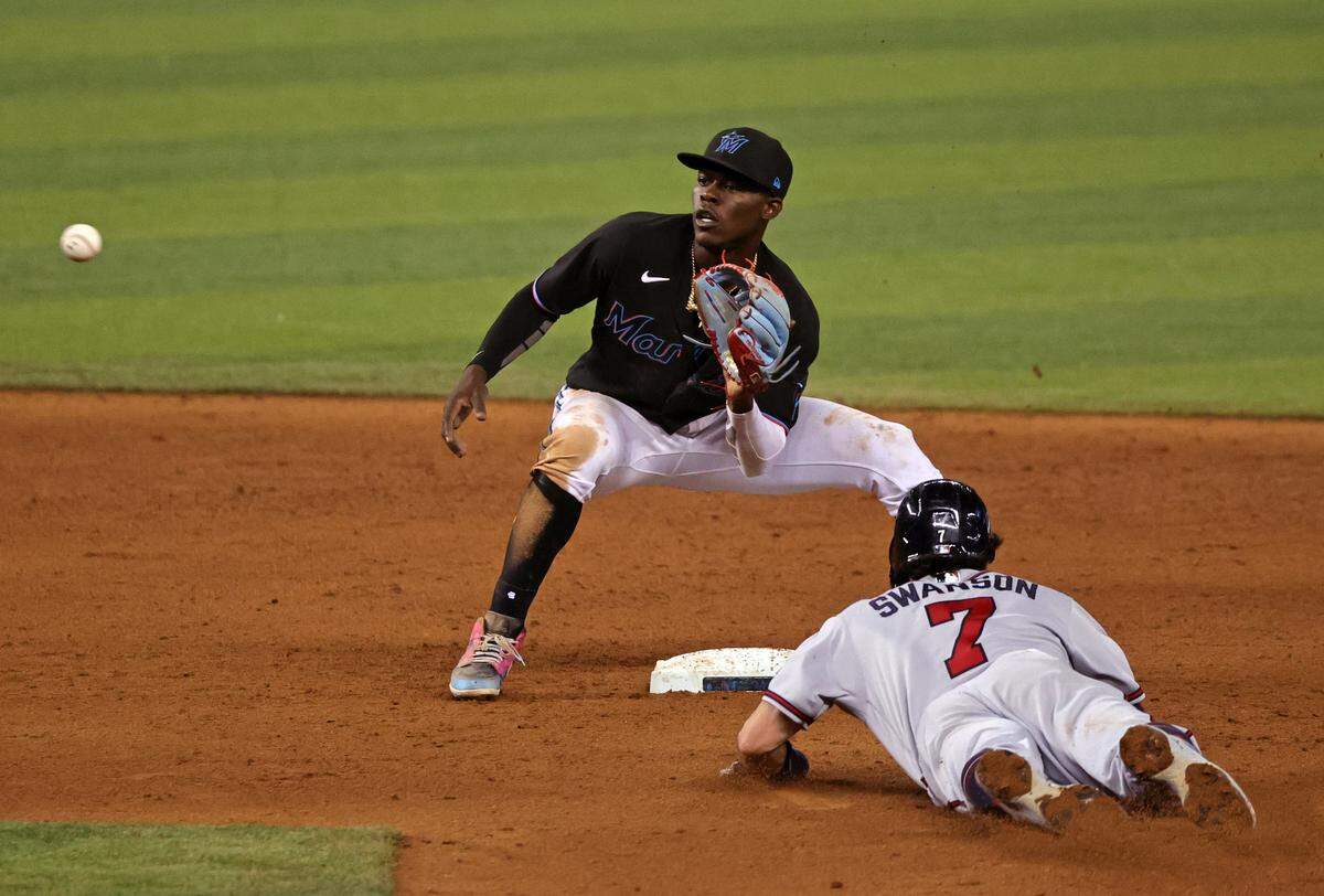 Atlanta Braves shortstop Dansby Swanson (7) slides into second as Miami Marlins shortstop Jazz Chisholm Jr. (2) catches the throw to tagged him out during the eighth inning of their baseball game at loanDepot park on Friday, June 11, 2021 in Miami, Florida.
