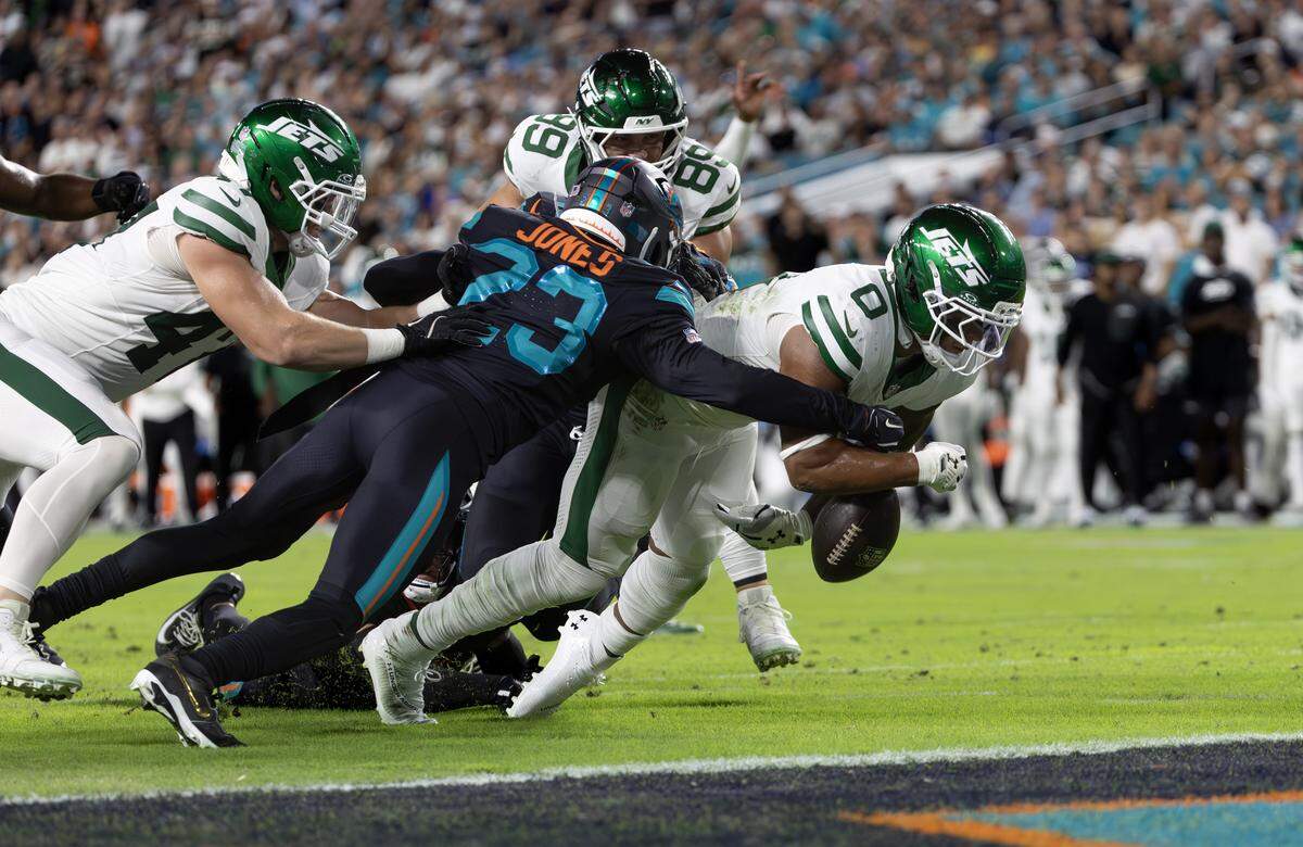 Miami Dolphins cornerback Jack Jones (23) forces a fumble on New York Jets running back Braelon Allen (0) during the first half of an NFL game at Hard Rock Stadium on Monday, Sept. 29, 2025, in Miami Gardens, Fla.
