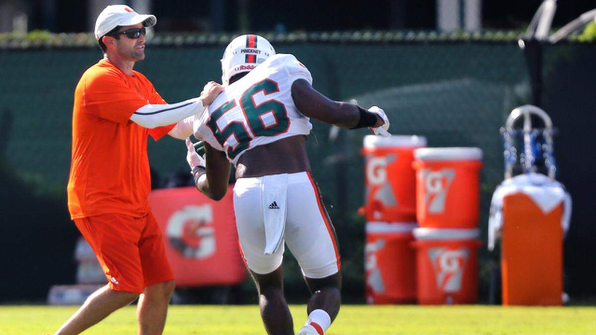 UM defensive coordinator Manny Diaz, left, goes through defensive drills during practice at the Greentree Practice Field on the Coral Gables University of Miami campus, Monday, August 6, 2018.