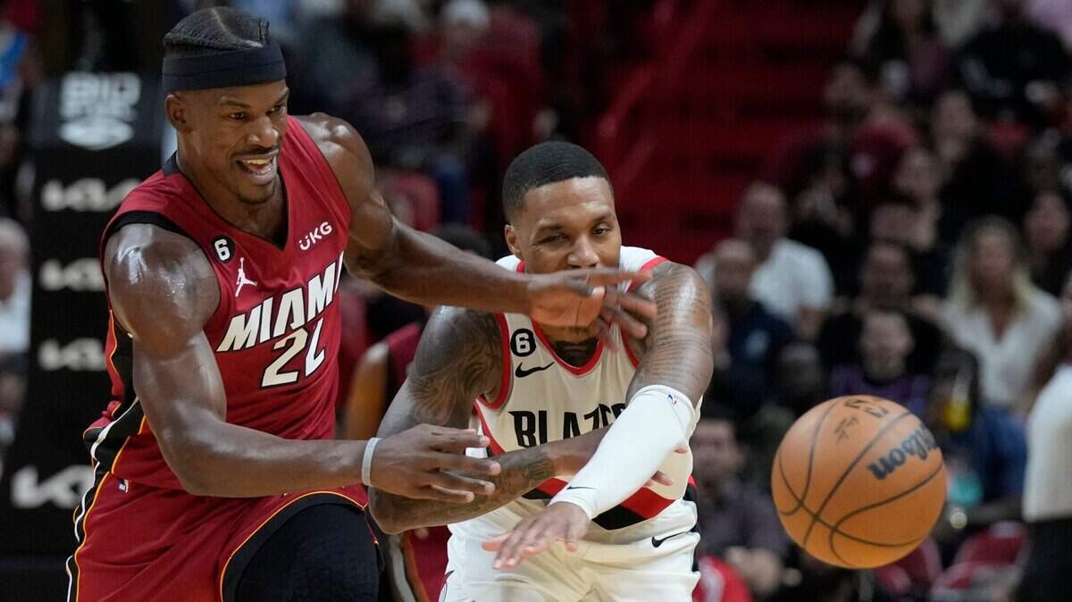 El jugador del Miami Heat, Jimmy Butler (izq.), y el escolta de los Trail Blazers de Portland, Damian Lillard, luchan por un balón durante la segunda mitad del partido celebrado el 7 de noviembre de 2022, en Miami.