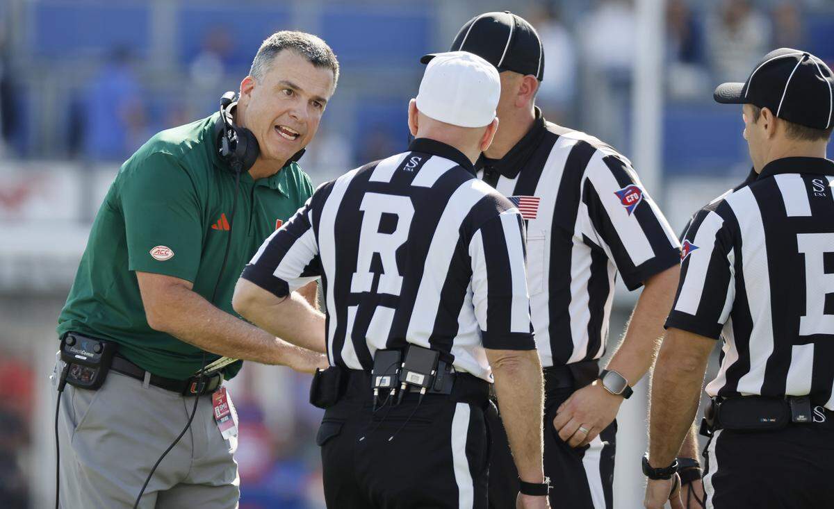 Miami Hurricanes head coach Mario Cristobal speaks with game officials during the second half of an NCAA football game against Southern Methodist University Mustangs at Gerald Ford Stadium on Saturday, November 1, 2025, in Dallas, Texas.
