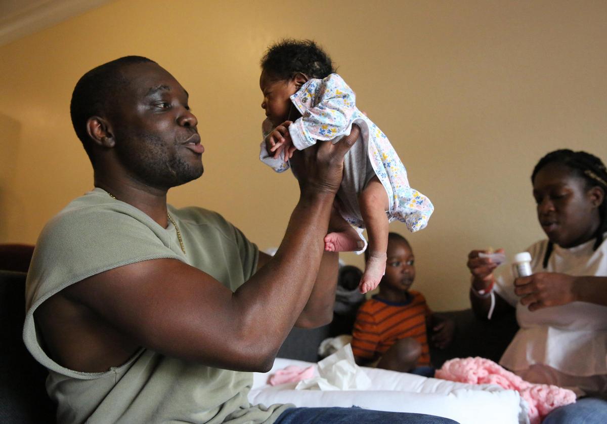 Jean Costume lifts his newborn baby daughter, Remy, into the air on her first day home from the hospital May 19, 2020. Remy was born during the coronavirus pandemic.