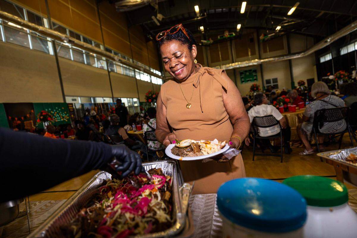 A woman is served a served a meal during the 18th Annual Haitian Thanksgiving Brunch