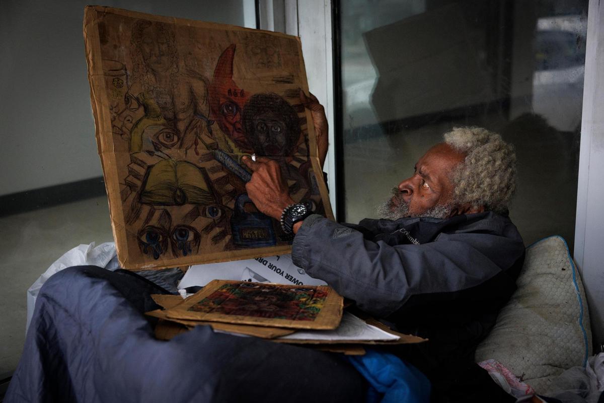 Eddie Fisher, friends with Marshall Ragsdale, one of two men beaten to death while they slept on the sidewalk in downtown Miami on Jan. 16, 2025, points to the devil in his artwork that he says is inspired by his life on the streets, Thursday evening, Jan. 23, 2025. He is sitting near the area where the attack occurred.