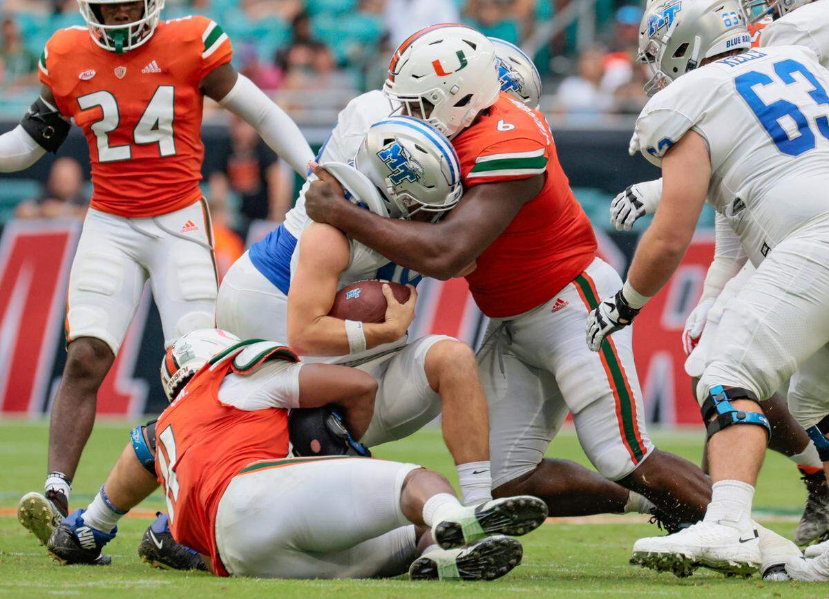 Miami Hurricanes defensive tackle Darrell Jackson tackles Middle Tennessee State quarterback Chase Cunningham at Hard Rock Stadium in Miami Gardens on Saturday, September 24, 2022.