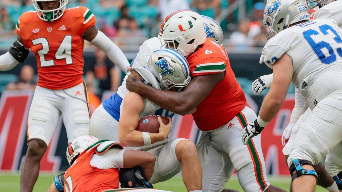 Miami Hurricanes defensive tackle Darrell Jackson tackles Middle Tennessee State quarterback Chase Cunningham at Hard Rock Stadium in Miami Gardens on Saturday, September 24, 2022.