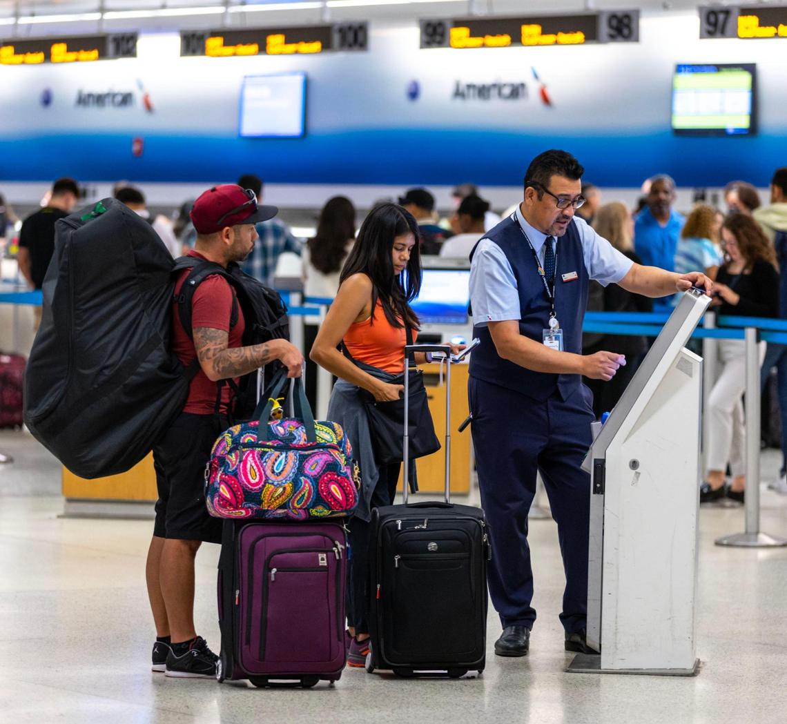 Viajeros son asistidos por el personal del aeropuerto mientras se registran para un vuelo en el Aeropuerto Internacional de Miami en Miami, Florida, el miércoles 23 de noviembre de 2022.