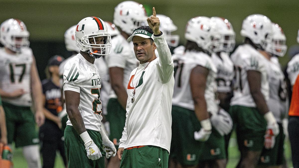 Miami Hurricanes head coach Manny Diaz directs players at Friday night’s opening of fall football camp.
