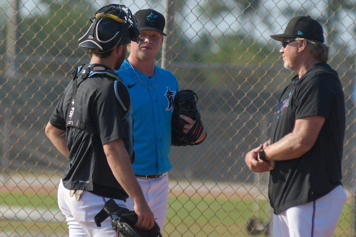 Miami Marlins pitcher Nic Enright (center) talks with catcher Cameron Barstad (left) and pitching coach Mel Stottlemyre Jr. after throwing a bullpen session on Wednesday, March, 8, 2023, at the Roger Dean Chevrolet Stadium complex in Jupiter, Florida.