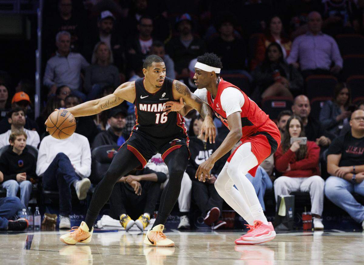 Miami Heat forward Keshad Johnson (16) keeps the ball from Toronto Raptors guard Ja'Kobe Walter (14) during the first half of a game on Dec. 15, 2025, at Kaseya Center in Miami.